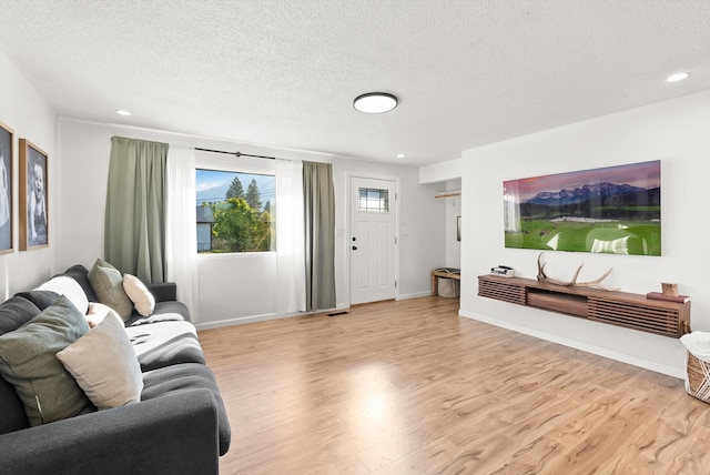 living room with light hardwood / wood-style flooring and a textured ceiling