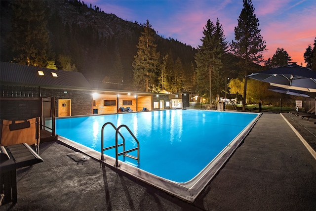 pool at dusk featuring a mountain view