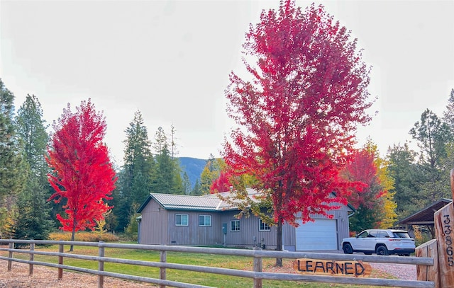 view of front facade with a mountain view, a front yard, and a garage