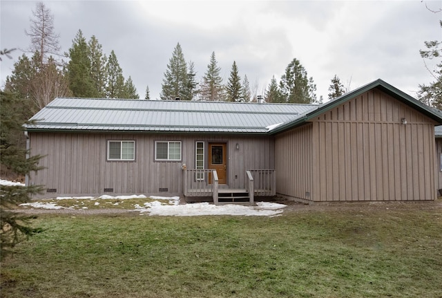 back of property featuring crawl space, a deck, metal roof, and a yard