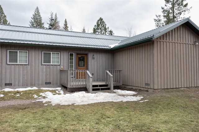 view of front of property with crawl space, board and batten siding, and metal roof