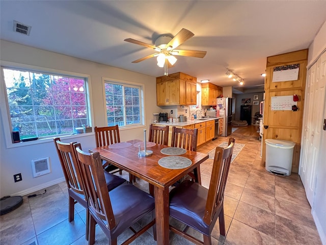 tiled dining room featuring ceiling fan and sink