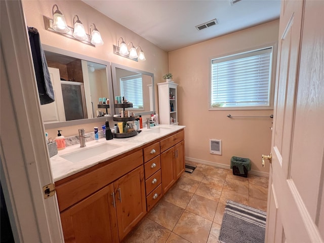 bathroom featuring tile patterned flooring, vanity, a wealth of natural light, and a shower with shower door