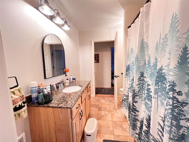 bathroom featuring tile patterned flooring, vanity, and toilet