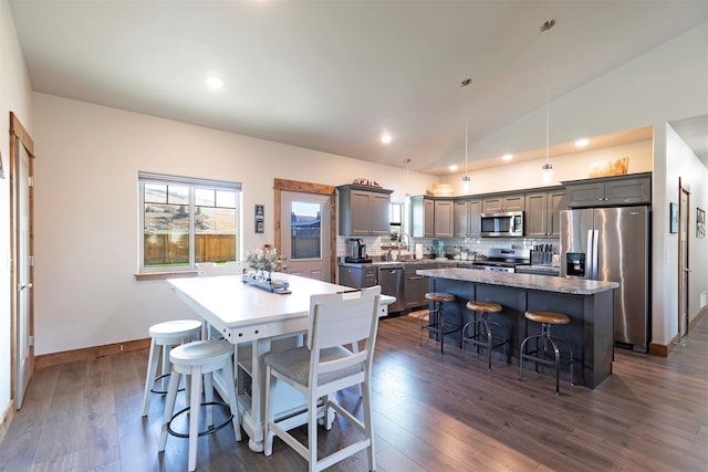 dining area featuring lofted ceiling, dark hardwood / wood-style flooring, and sink