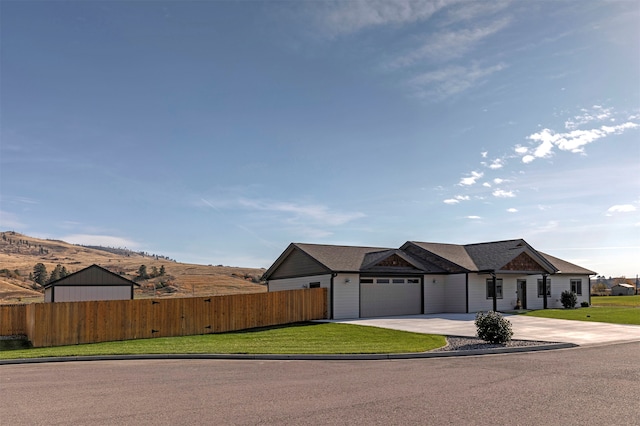 single story home with a mountain view, a garage, and a front lawn