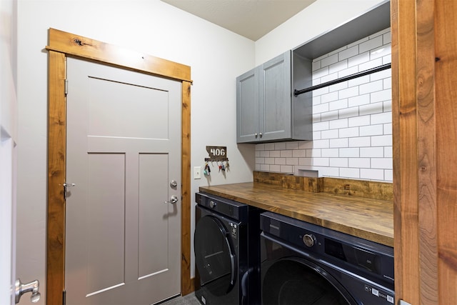 laundry area with washing machine and dryer and cabinets