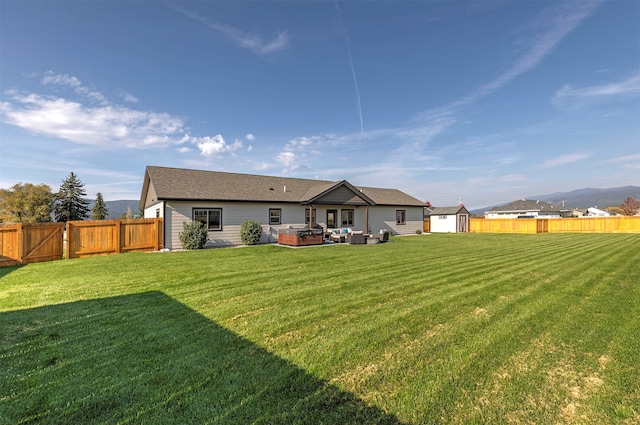 back of property featuring a yard, a storage unit, and a mountain view