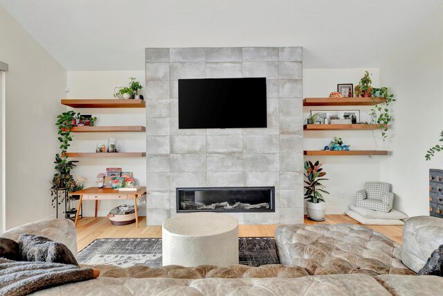 living room featuring hardwood / wood-style flooring and a tiled fireplace