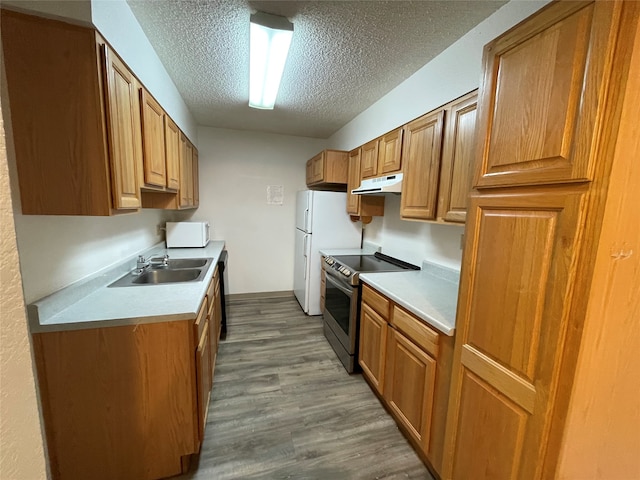 kitchen with white appliances, sink, a textured ceiling, and hardwood / wood-style flooring