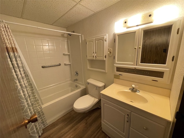 full bathroom with toilet, a paneled ceiling, shower / bath combo, hardwood / wood-style flooring, and vanity