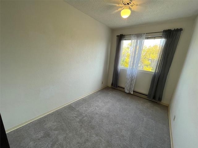 carpeted empty room featuring ceiling fan and a textured ceiling