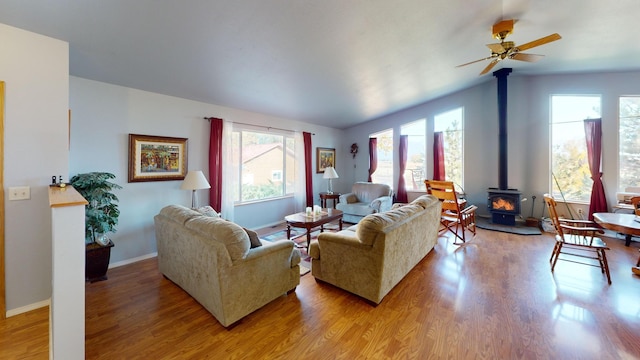 52772 Herak Rd, Charlo, MT 59824 - living room with lofted ceiling, a wood stove, light wood-style floors, baseboards, and ceiling fan