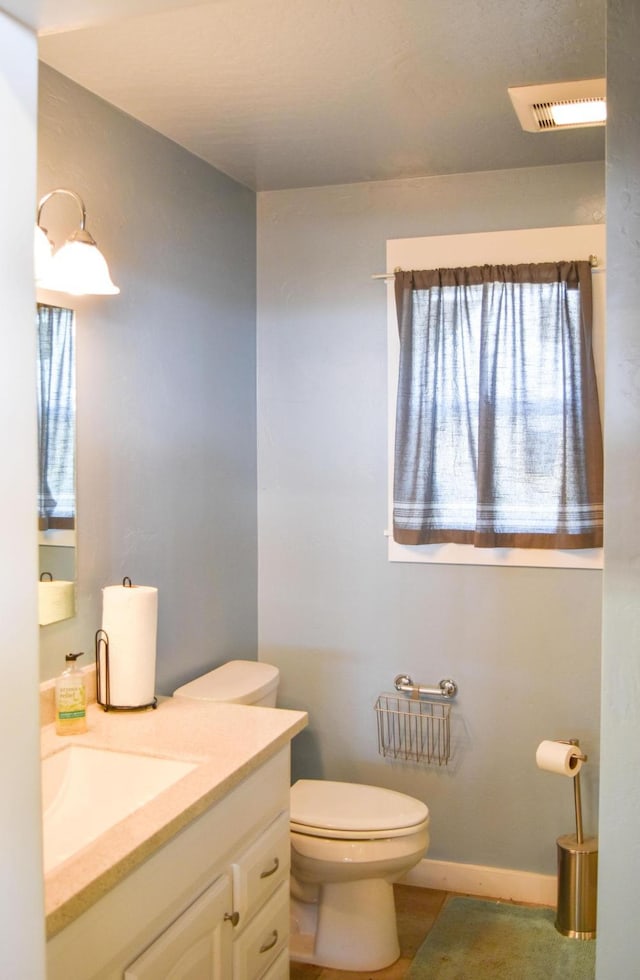52772 Herak Rd, Charlo, MT 59824 - half bath with visible vents, baseboards, vanity, and toilet