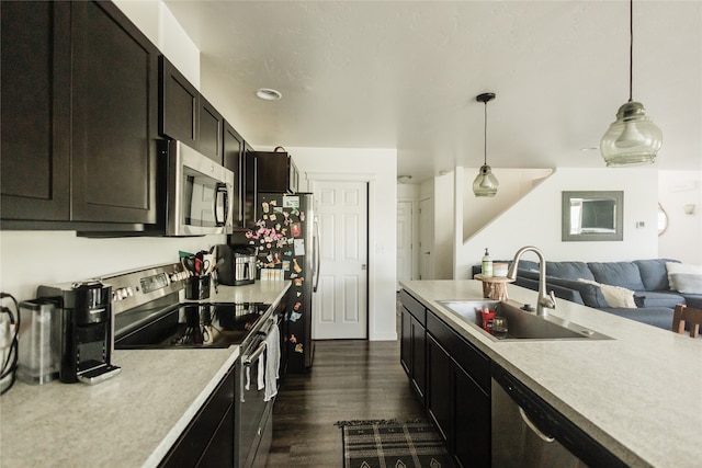 kitchen featuring decorative light fixtures, appliances with stainless steel finishes, dark hardwood / wood-style flooring, and sink