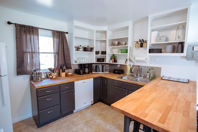 kitchen with wood counters, white appliances, and sink