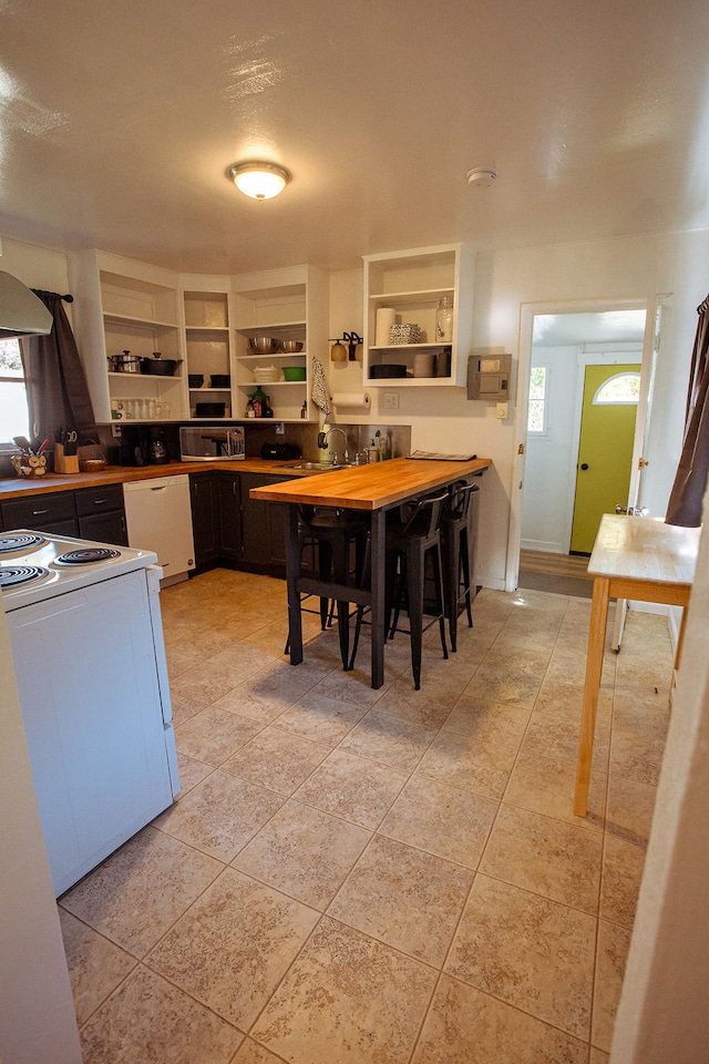 kitchen featuring light tile patterned flooring, white appliances, and sink