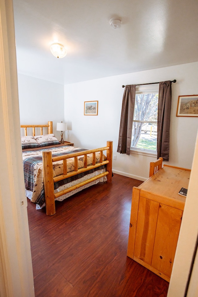 bedroom with dark hardwood / wood-style floors