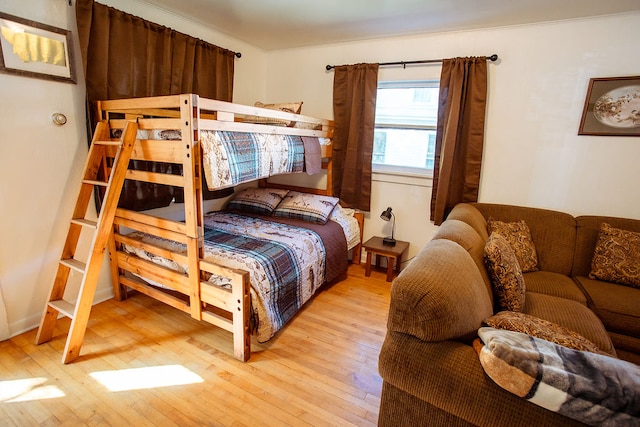 bedroom with crown molding and light hardwood / wood-style flooring