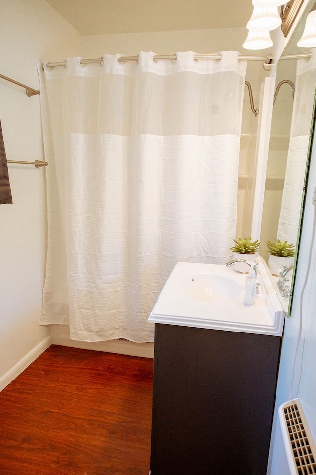 bathroom with walk in shower, hardwood / wood-style flooring, and vanity