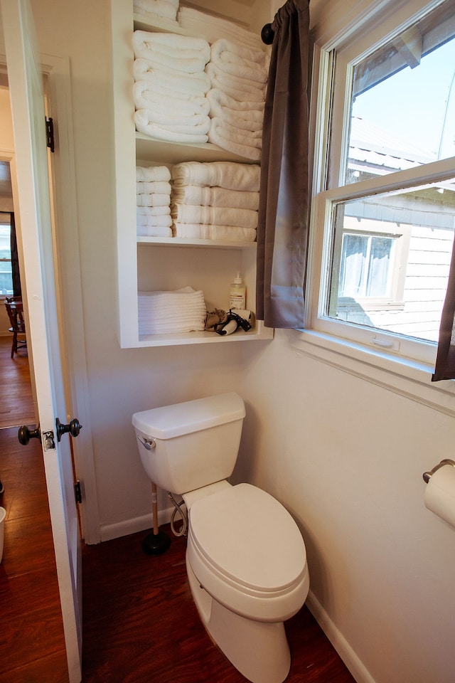 bathroom with hardwood / wood-style flooring and toilet