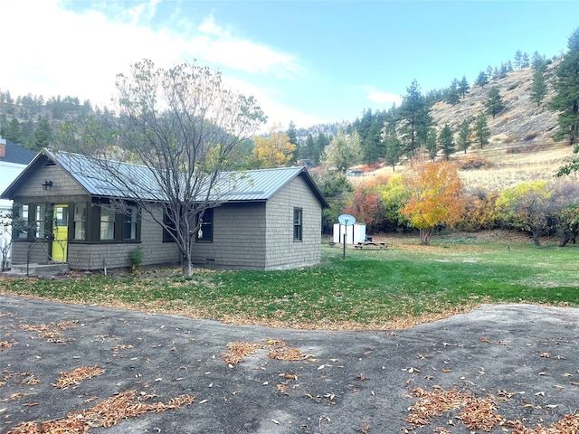 view of side of property with a lawn and a mountain view