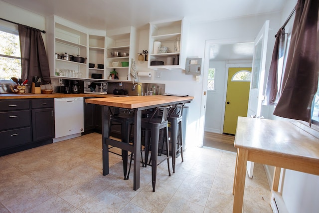 kitchen with butcher block countertops, dishwasher, and sink