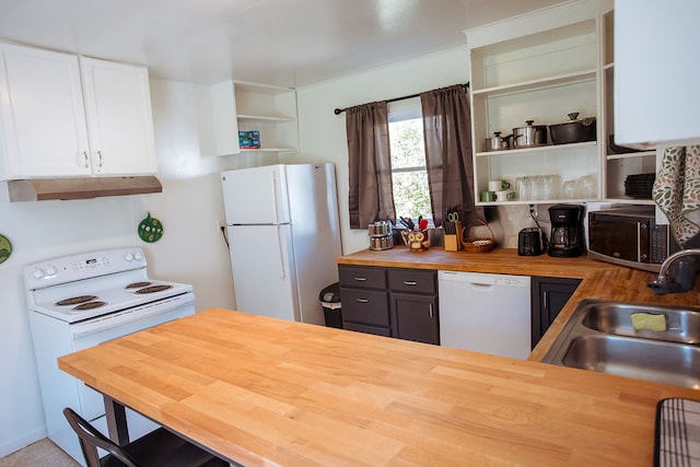 kitchen with white appliances, range hood, sink, butcher block counters, and white cabinetry