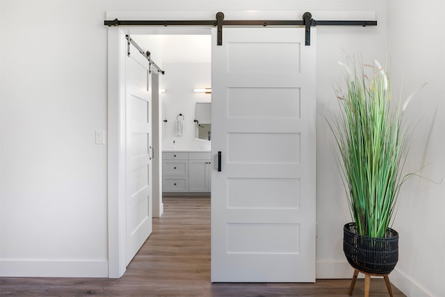 hall with hardwood / wood-style floors and a barn door