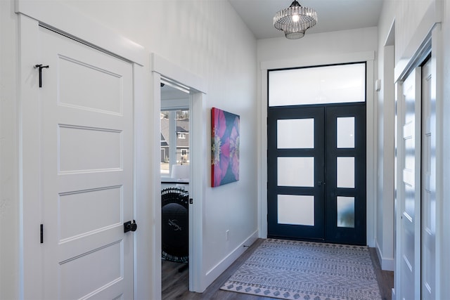 foyer featuring dark wood-type flooring and a chandelier