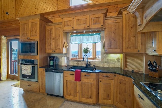 kitchen with tasteful backsplash, dark stone countertops, sink, light tile patterned flooring, and appliances with stainless steel finishes