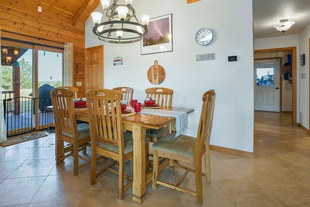 dining room with vaulted ceiling with beams, wood ceiling, light tile patterned floors, wooden walls, and a chandelier