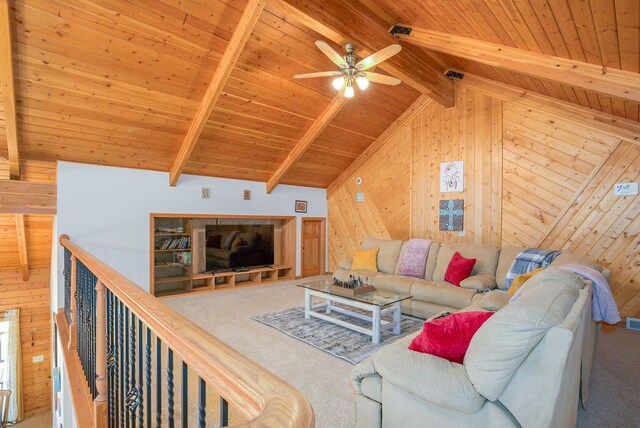 carpeted living room featuring ceiling fan, wooden walls, lofted ceiling with beams, and wooden ceiling