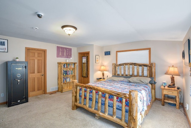 bedroom with light colored carpet and vaulted ceiling