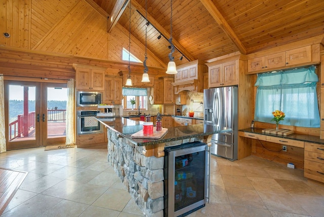 kitchen with a water view, beverage cooler, stainless steel appliances, high vaulted ceiling, and a spacious island