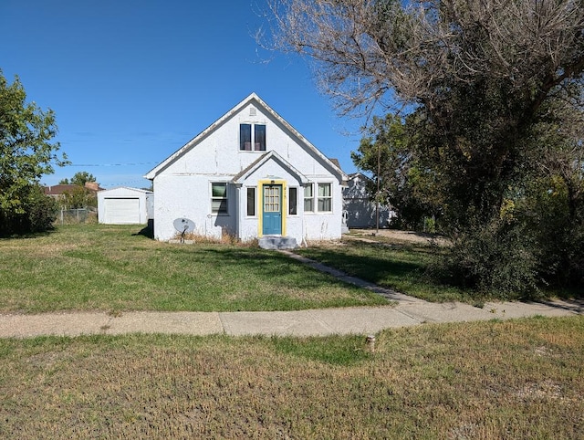 view of front of house featuring a garage, an outdoor structure, and a front lawn