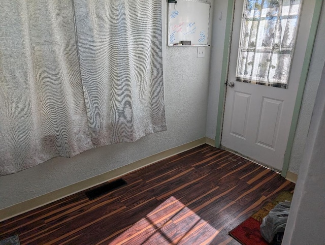 doorway with dark wood-type flooring