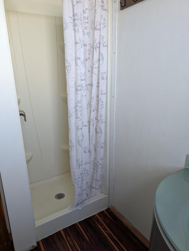 bathroom with a shower with curtain and hardwood / wood-style flooring