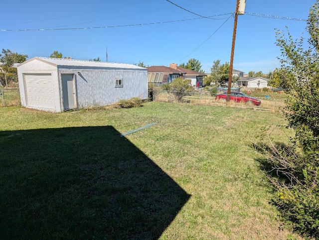 view of yard with a garage and an outbuilding