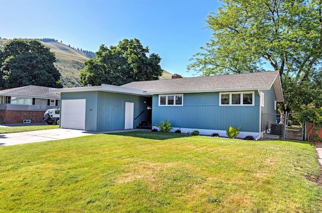 single story home featuring a mountain view, a garage, and a front lawn