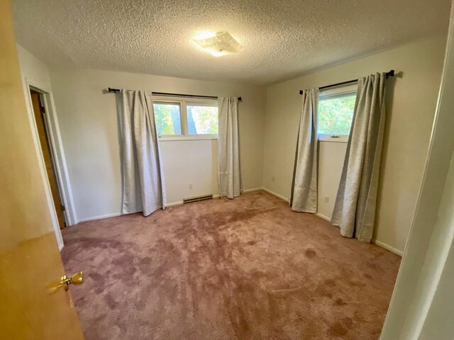 414 2nd St W, Chester, MT 59522 - unfurnished bedroom with multiple windows, carpet, a textured ceiling, and baseboards