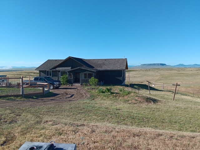 view of front of house with a mountain view, a rural view, and a front yard