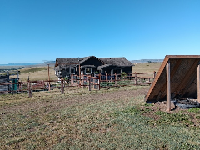 view of jungle gym featuring a mountain view, an outbuilding, and a rural view