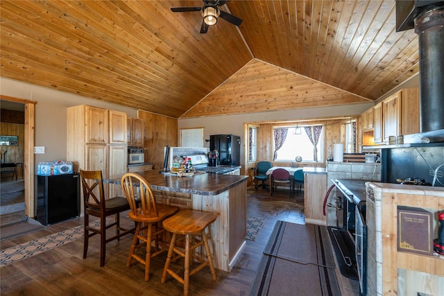 kitchen with light brown cabinetry, black fridge, wood ceiling, ceiling fan, and dark wood-type flooring