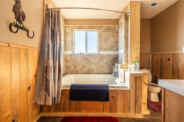 bathroom with wood walls, shower / bath combo, and toilet