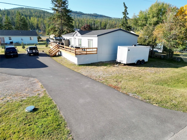 view of side of home featuring a wooden deck and a lawn