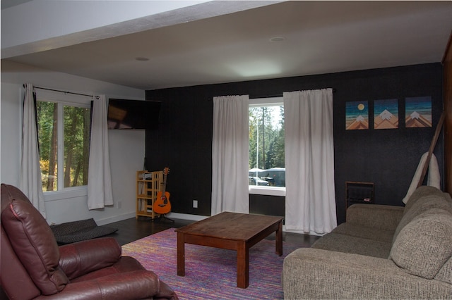 living room with dark wood-type flooring and a healthy amount of sunlight