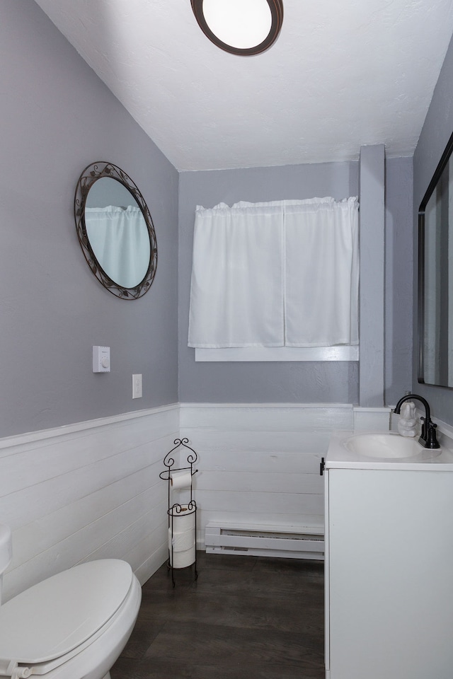 bathroom featuring vanity, hardwood / wood-style floors, toilet, and a baseboard radiator