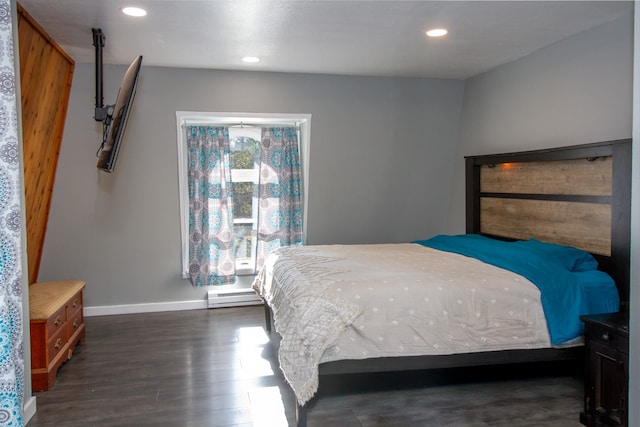 bedroom with a baseboard heating unit and dark wood-type flooring