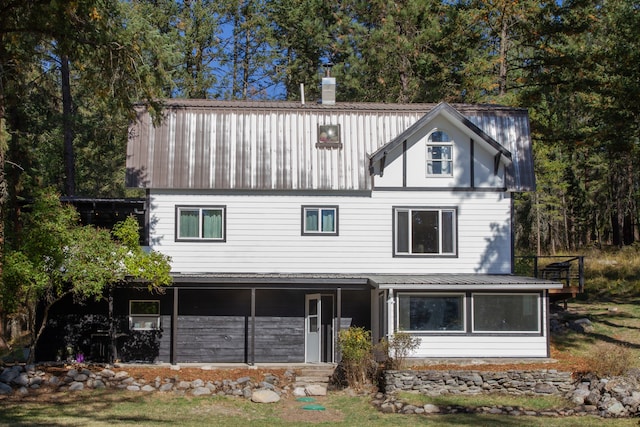 rear view of property featuring metal roof and a chimney